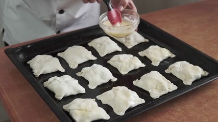 Wall Mural - Smear the pies with egg yolk, homemade baking