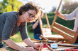 © jackfrog - A man and his family are building wooden containers for their vegetable garden on the terrace.