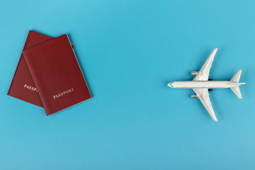 travel concept. Conceptual photo of a tourist trip. two passports and airplane on a blue background flat lay with copy space