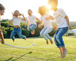 © nuzza11 - A group of children have fun playing in nature. Children jump over the rope. Warm summer evening with sunset light.