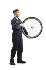 Poster - Young bicycle mechanic carrying a tire