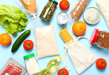 Wall Mural - Food supplies for the period of quarantine on blue background. Set of grocery items from canned food, vegetables, pasta, cereal. Food delivery concept. Donation concept. Top view.