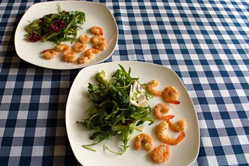 green salad with shrimp for two guests on a table with a tablecloth