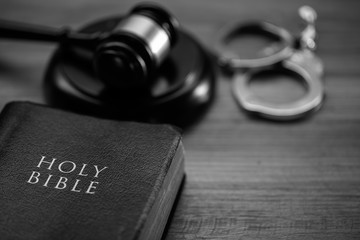 Wall Mural - Black and white image of a gavel, handcuffs and a bible