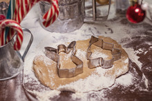 Raw Gingerbread Brown Spicy Dough With Metal Shapes Of Angel And Christmas Tree On A Wooden Table With Caramel Cane And Red Christmas Toys
