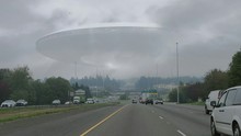 Cars On Street Against Flying Saucer In Cloudy Sky