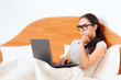 © nicoletaionescu - Worried Woman Looking at Laptop Sitting in Bed