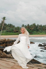 Wall Mural - Bride is dancing at the beach. Happy bride in wedding dress dancing on the beach