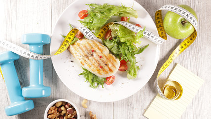 Wall Mural - grilled chicken fillet with salad- dumbbell and meter tape- diet food concept