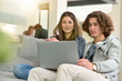 © goodluz - Young couple of students at home watching movie on laptop