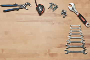 spanners and variety of material on a wooden background with space