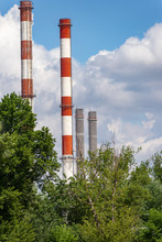 Image Of The Chimneys Of The City Heating Plant With Trees And With Clouds