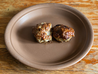 two fried russian Kotleta (breaded minced beef steaks) on ceramic plate on old wooden table at home kitchen