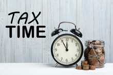 Time To Pay Taxes. Alarm Clock, Glass Jar And Coins On White Table