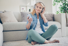 Photo Of Funny Feel Young Middle Aged Domestic Lady Sit Comfy Floor Couch Browsing Telephone Listen Music Cool Earphones Remote Work Stay Home Quarantine Weekend Living Room Indoors