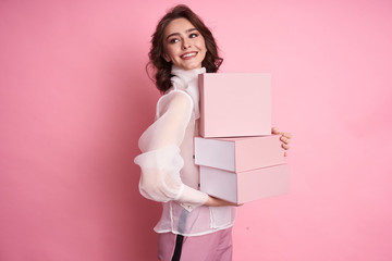  Young girl holding a pink box on a pink background