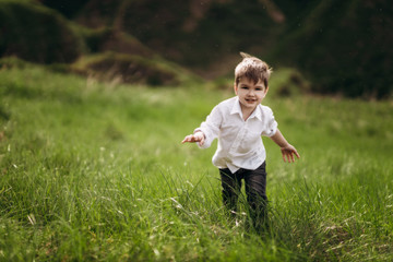 child with a smile on the green hills, fields