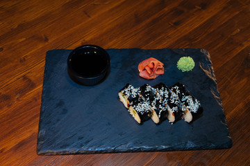 Wall Mural - A set of sushi. Philadelphia roll, California, unagi, black dragon with fresh ingredients on a black background. The sushi menu. Japanese cuisine. Ginger and wasabi. Soy sauce