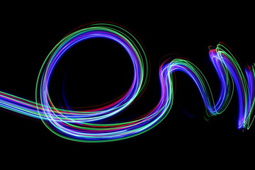 Wall Mural - Long exposure photograph of neon multi colour in an abstract swirl, parallel lines pattern against a black background. Light painting photography.