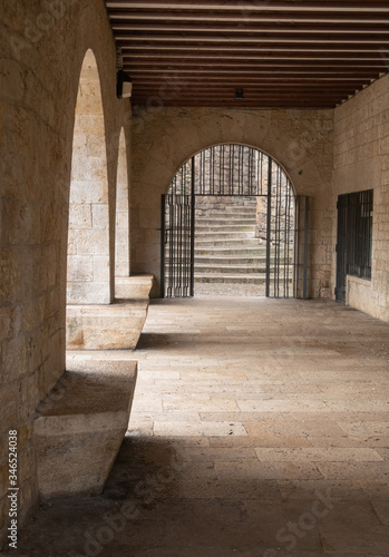 Fotografía Antiguo corredor cubierto con arcada y puerta con rejas
