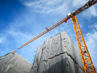 Tower crane in building construction site low angle view.