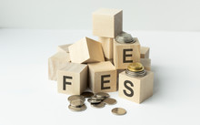 Coin Stack And Wooden Blocks With The Fee Text. Fee Finance And Money Concept.