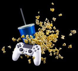 Wall Mural - Flying popcorn, cup of soft drink and video game joystick isolated on black