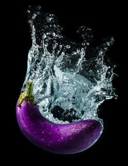 Wall Mural - Water splashing with purple eggplant.