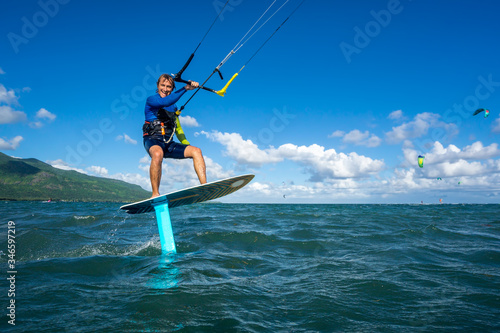 Plakaty Kitesurfing  profesjonalny-kiter-t-jezdzi-wodolotem-na-pieknym-tle-gory-sprayu-i-piekna