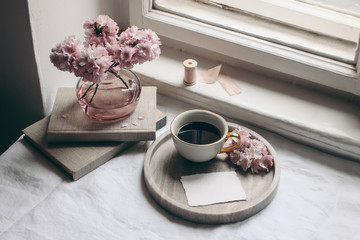 spring still life composition. greeting card mockup, marble tray, cup of coffee, old books. vintage 