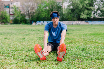 young guy does warm-up at the stadium before running