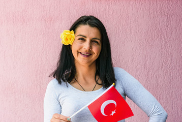 Sticker - Woman holds flag of Turkey in front of isolated wall background