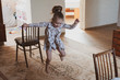 © Kiryakova Anna - A happy girl jumps through an elastic band strung between chairs. Idea for quarantined child activity