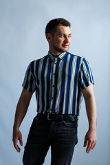 Wall Mural - Young man in a striped classic shirt on a white background. Stylish guy dressed in casual style. Male image for every day