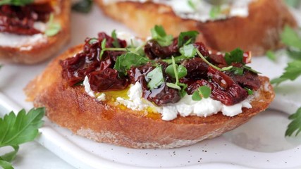 Wall Mural - Toasts with cream cheese, sun-dried tomatoes and herbs are poured with olive oil.