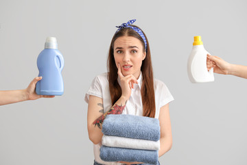 Canvas Print - Young woman with clean towels and hands with detergents on grey background