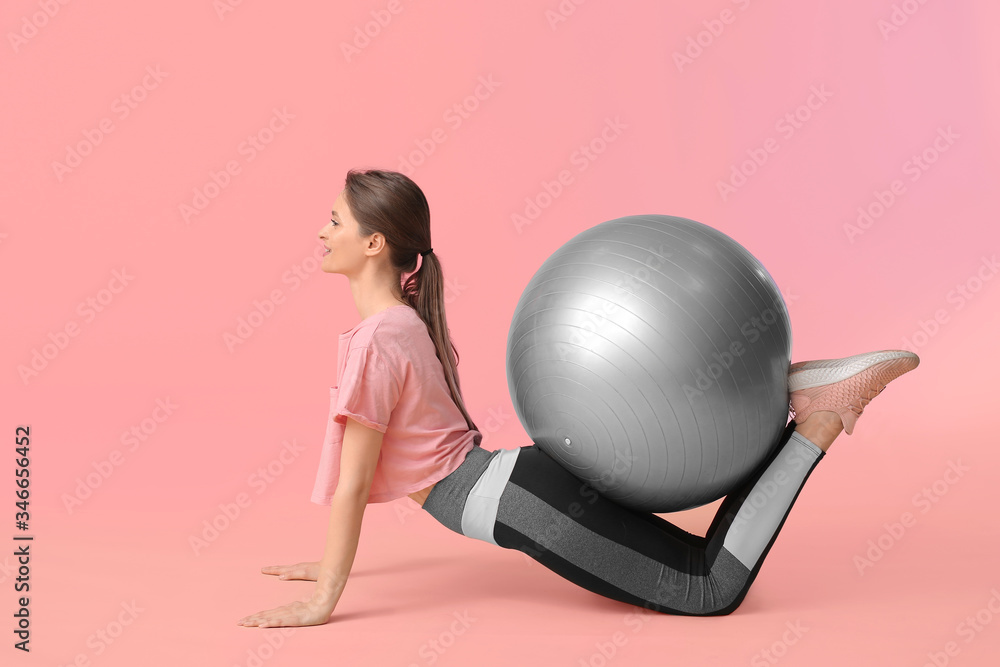 Sporty young woman training against color background