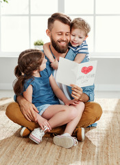 Wall Mural - happy father receiving greeting card from kids.