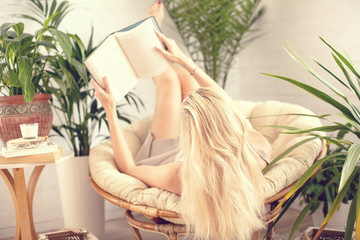 Woman relaxing at boho home with book