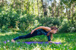 © Smile - Young woman doing yoga exercises in summer city park.