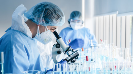 Wall Mural - biochemical research scientist team working with microscope for coronavirus vaccine development in p