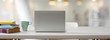 © bongkarn - Close up view of comfortable worktable with open laptop, books, mug and copy space on white table