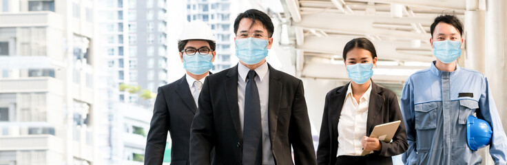 Confident business people with face mask protect from Coronavirus or COVID-19. Concept of help, support and collaboration together to overcome epidemic of Coronavirus or COVID-19 to reopen business.