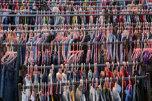 Huge Selection Of Different Used Clothes For Men, Women And Children On The Rack In A Second Hand Shop Or Thrift Store. Concept Of Waste Problem In Fashion Industry.