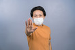 © THANANIT - Portrait of asian male wearing face surgical mask and say no action to coronavirus  infection on blue color background, covid19 outbreak and pandemic, healthcare and protection against virus concept