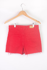 Wall Mural - female red cropped denim shorts with a high waist on a hanger isolated on white, front ana back