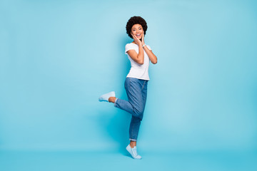 Canvas Print - Full body photo of pretty funky dark skin curly lady enjoy sightseeing walk down street sunny summer day tourist traveler wear casual white t-shirt jeans isolated blue color background