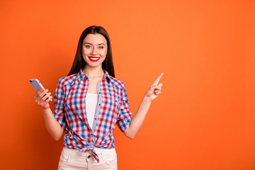 Poster - Portrait of positive confident cool girl cute promoter search ads indicate promotion point index finger wear white pants trousers good looking outfit isolated over orange color background