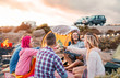 Happy friends toasting beers at barbecue camping party - Group young hipster people having fun dining and drinking together in campsite - Travel vacation lifestyle and youth culture concept