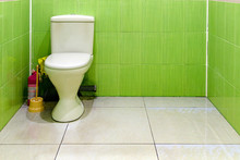 White Toilet In Beige And Green Bathroom